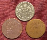 Three coins: 1 Dime, 1 penny, and a penny shaved to the size of a dime